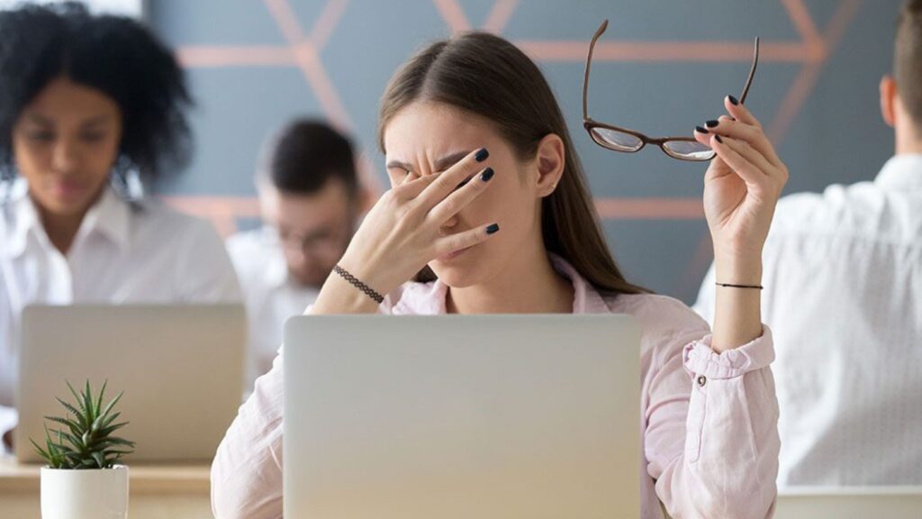 A stressed female employee showcasing her mental health at a healthy workplace