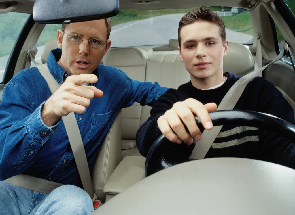 a driving instructor giving instructions to his student